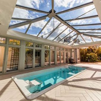 A “Seriously Convenient” Pool under a Grand Glass Roof